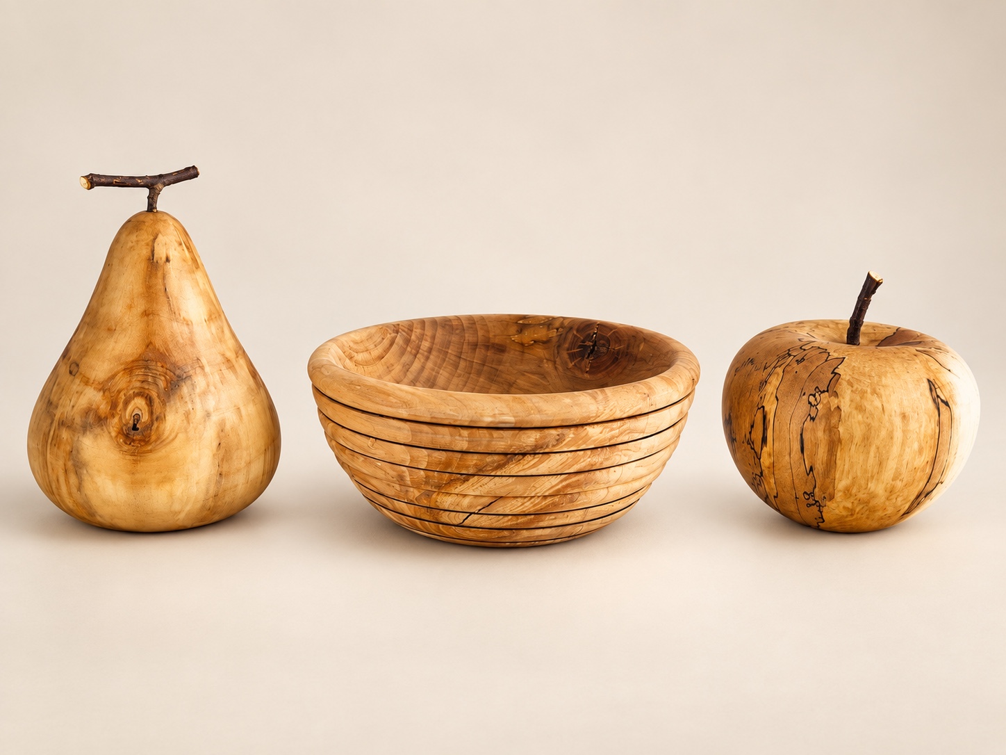 Poire, bol et pomme tournés à la main, présentés entièrement sur un fond clair