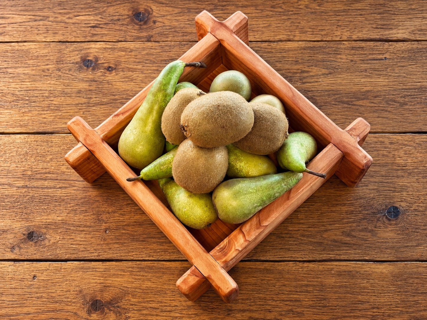 Vue de dessus de la corbeille à fruits en pin Douglas garnie de poires et de kiwis
