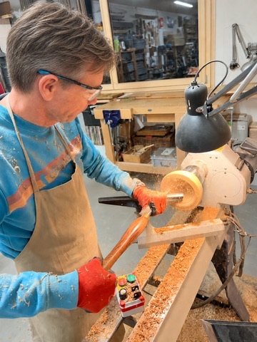 Franck façonnant un bol sur son tour à bois dans son atelier