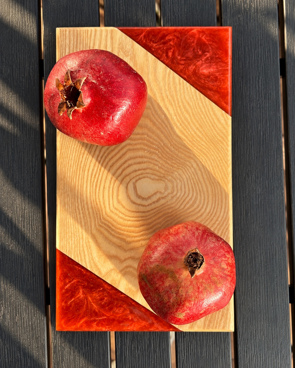Vue de dessus de la planche en frêne avec deux angles en époxy rouge et des grenades