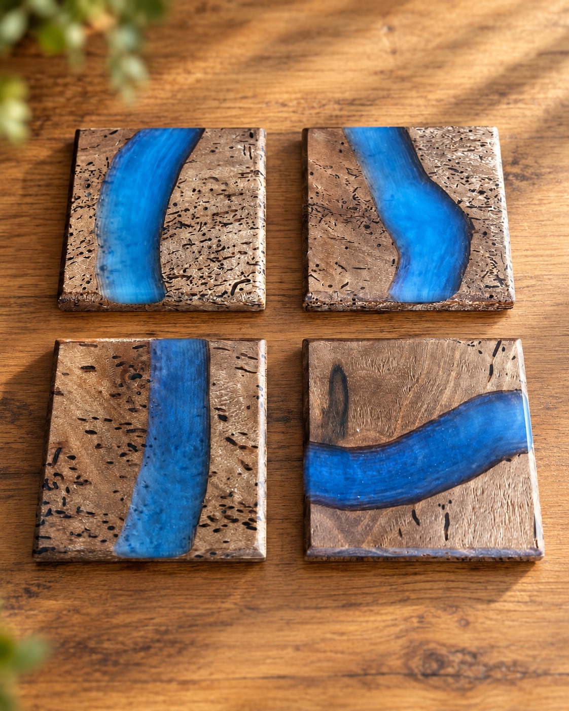 Ensemble de quatre sous-verres en noyer vermoulu avec rivières époxy bleues