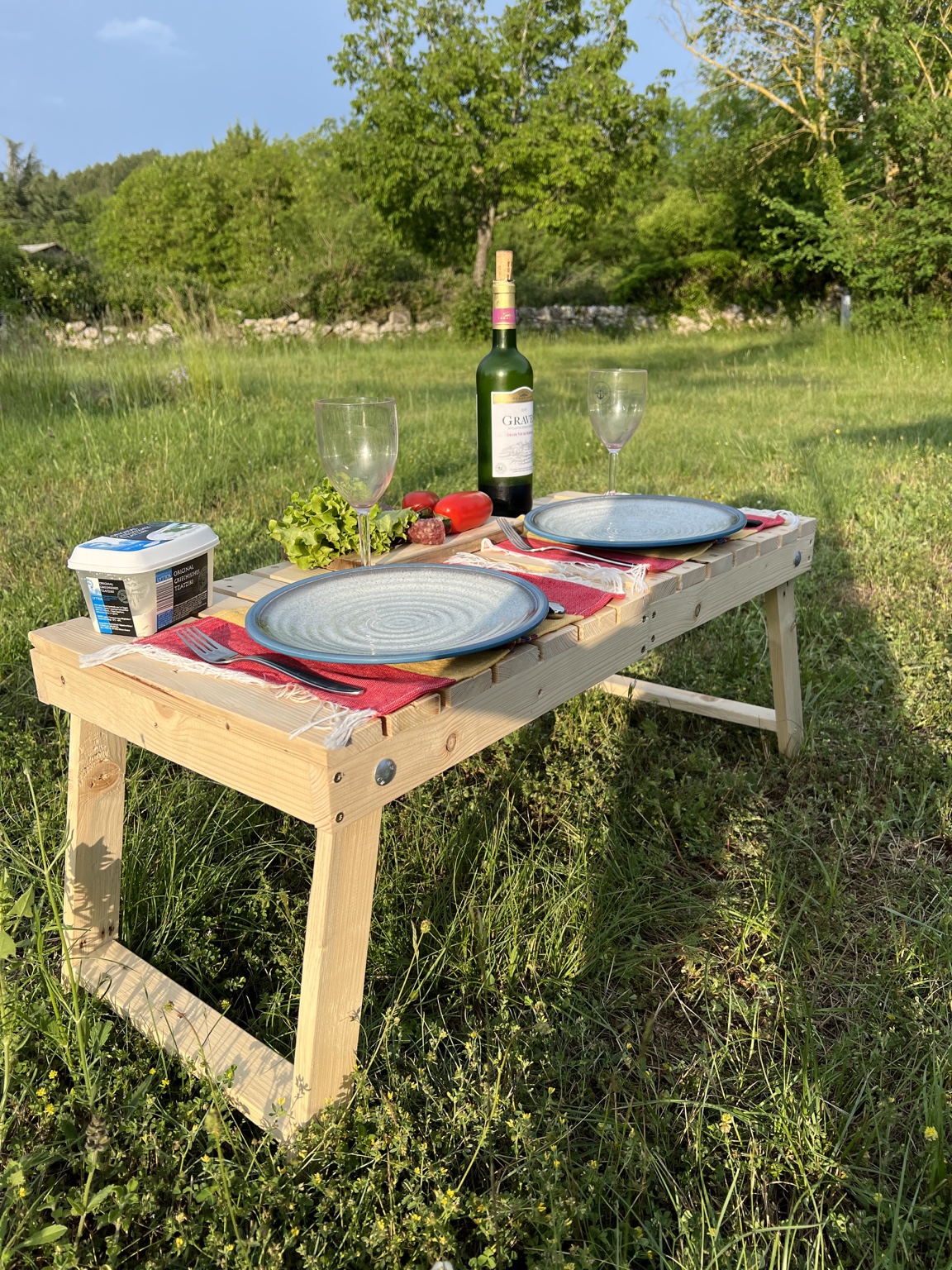 Table de pique-nique dressée pour un déjeuner dans une prairie